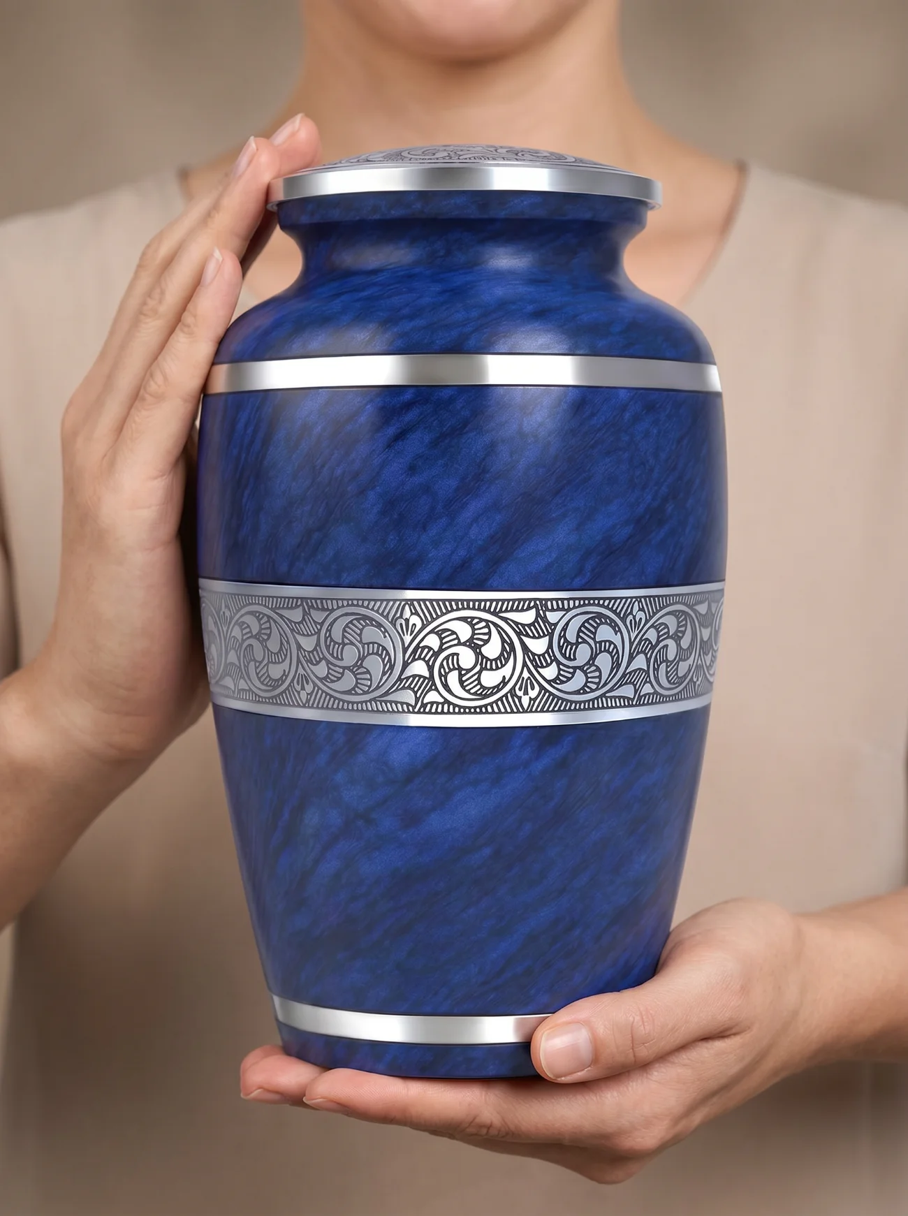 Person holding the gold marble urn to show its scale