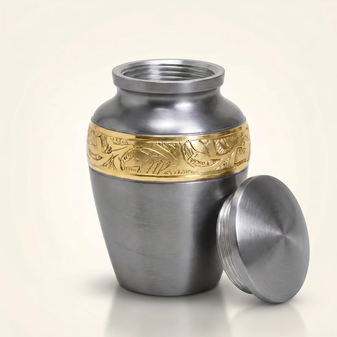 Grey keepsake urn with the threaded gold lid removed