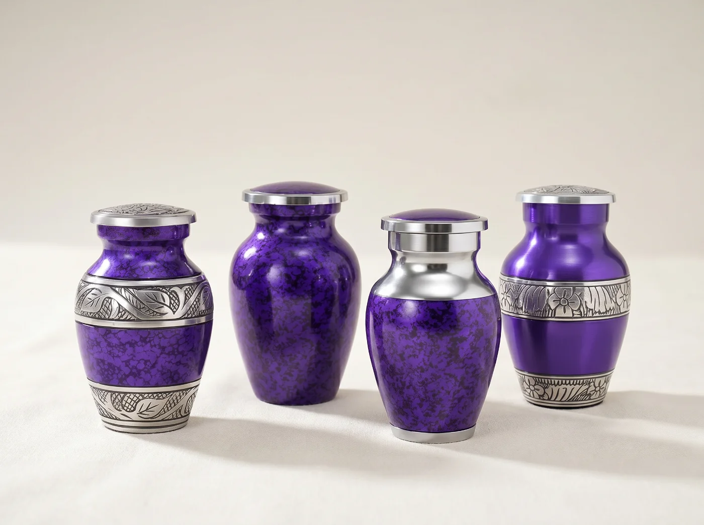 Set of four matching keepsake urns with velvet bags