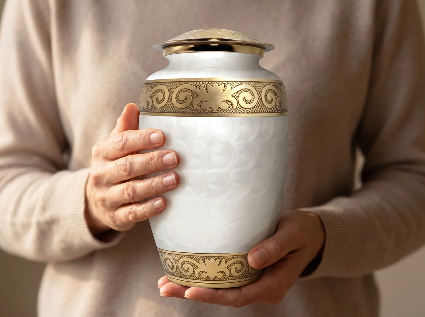 Person holding the white and gold enamel urn to show its scale