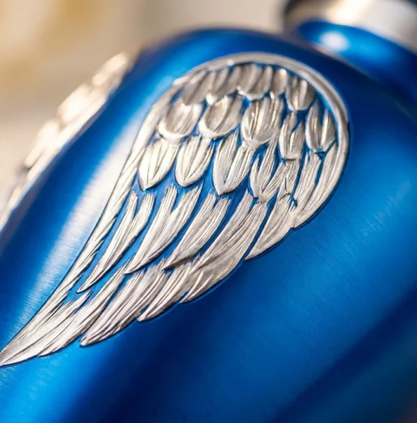 Close-up of the engraved silver angel wings and blue finish