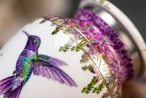 Close-up of the hand-painted hummingbird, purple wisteria flowers and silver engraved band
