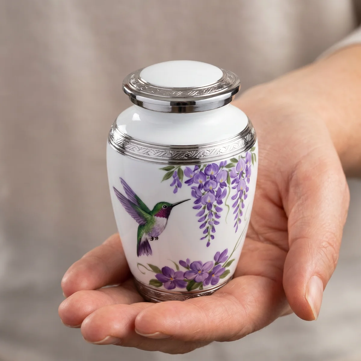 Single white hummingbird keepsake urn in an open palm to show its size