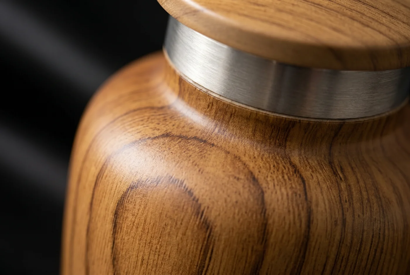 Close-up of the teak wood-grain finish and silver engraved band